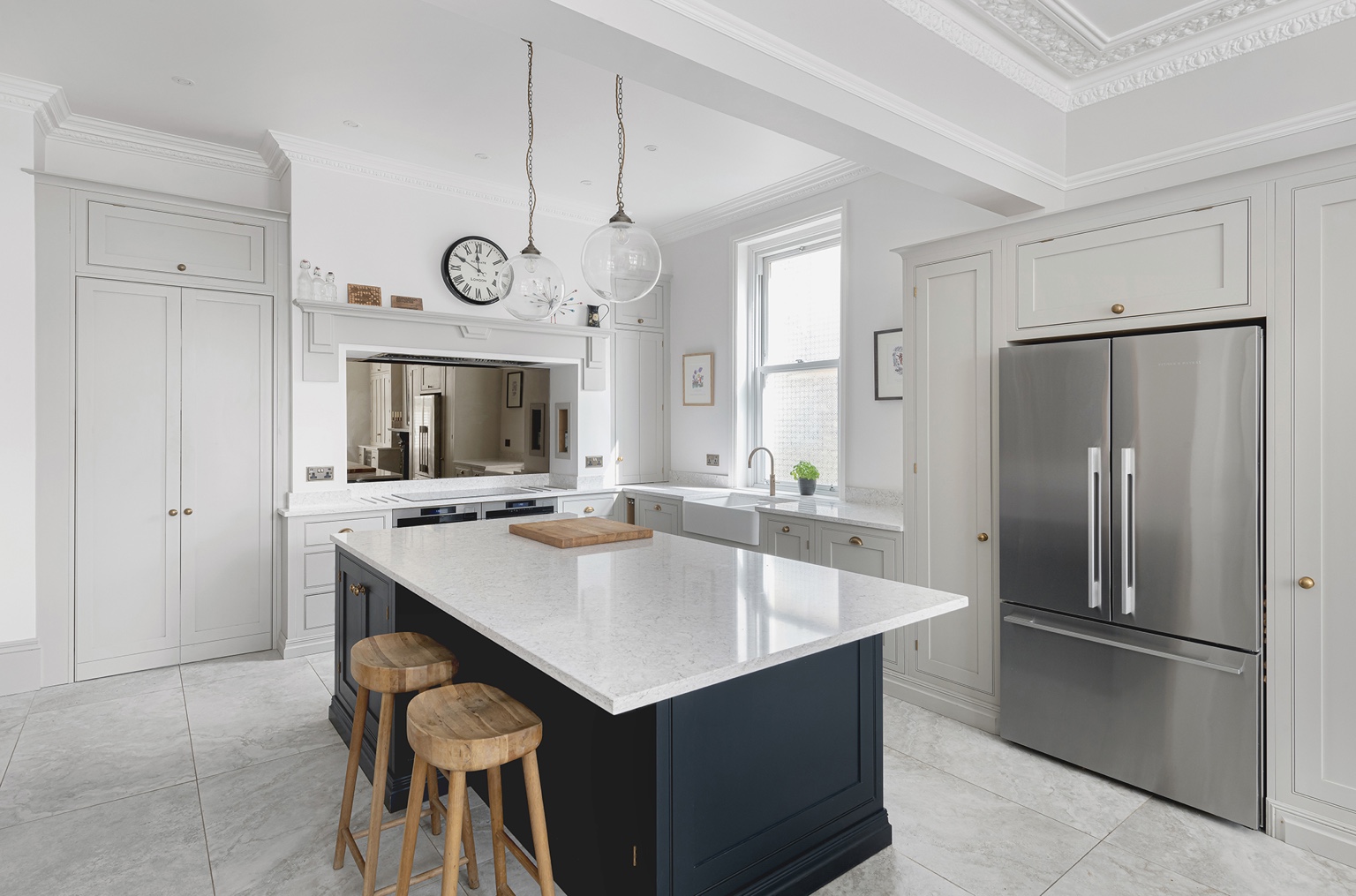 Davies & King kitchen project with a dark island, pale cabinetry and period cornicing
